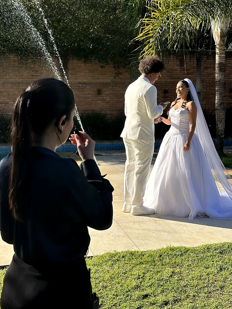 Assessora fotografando os noivos no jardim antes da cerimônia