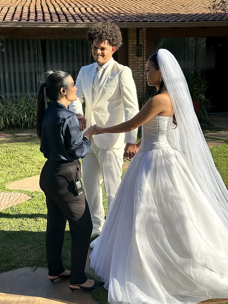 Assessora da Unità ajustando o vestido da noiva antes da cerimônia