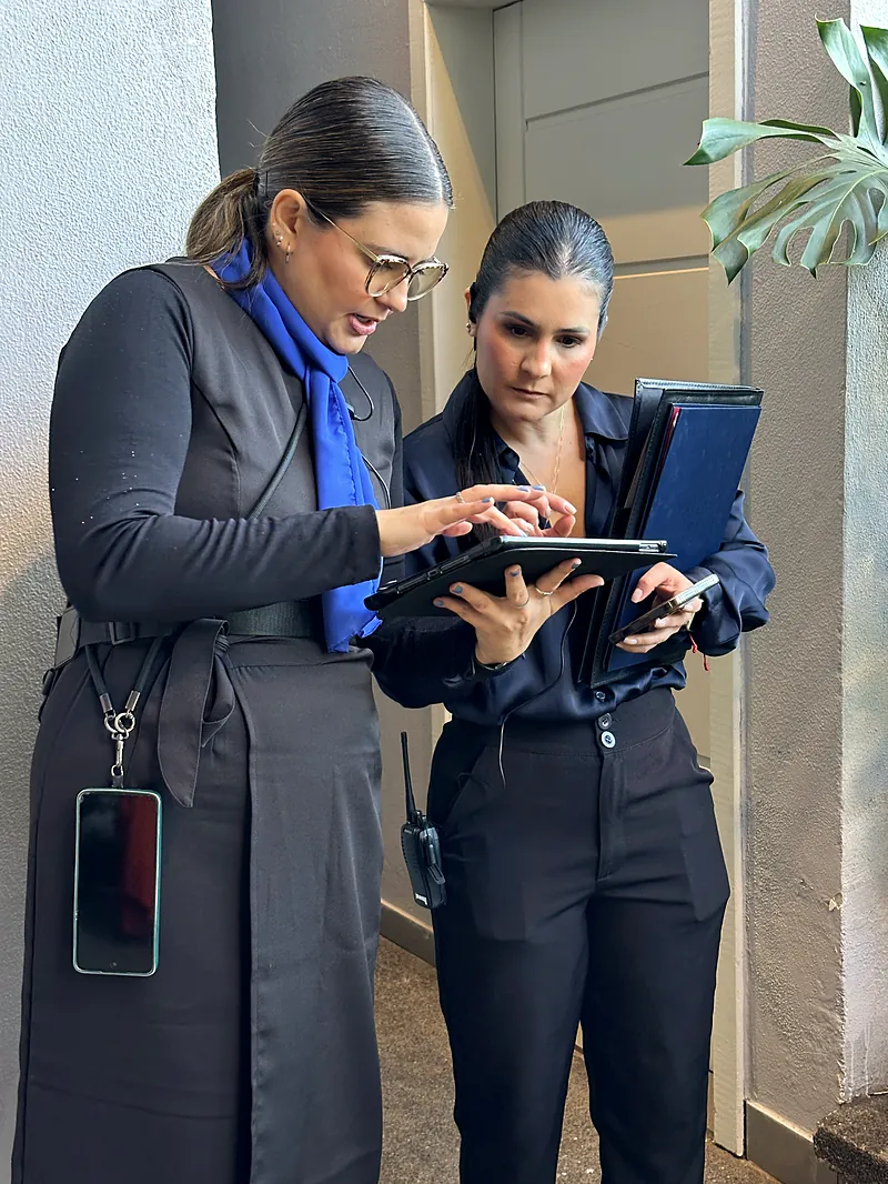 Integrantes da equipe Unità conferindo o cronograma em um tablet
