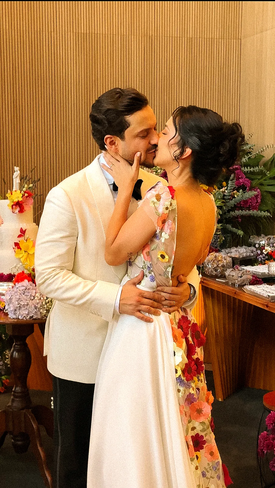 Bia e Paulinho se beijando diante da mesa de doces florida