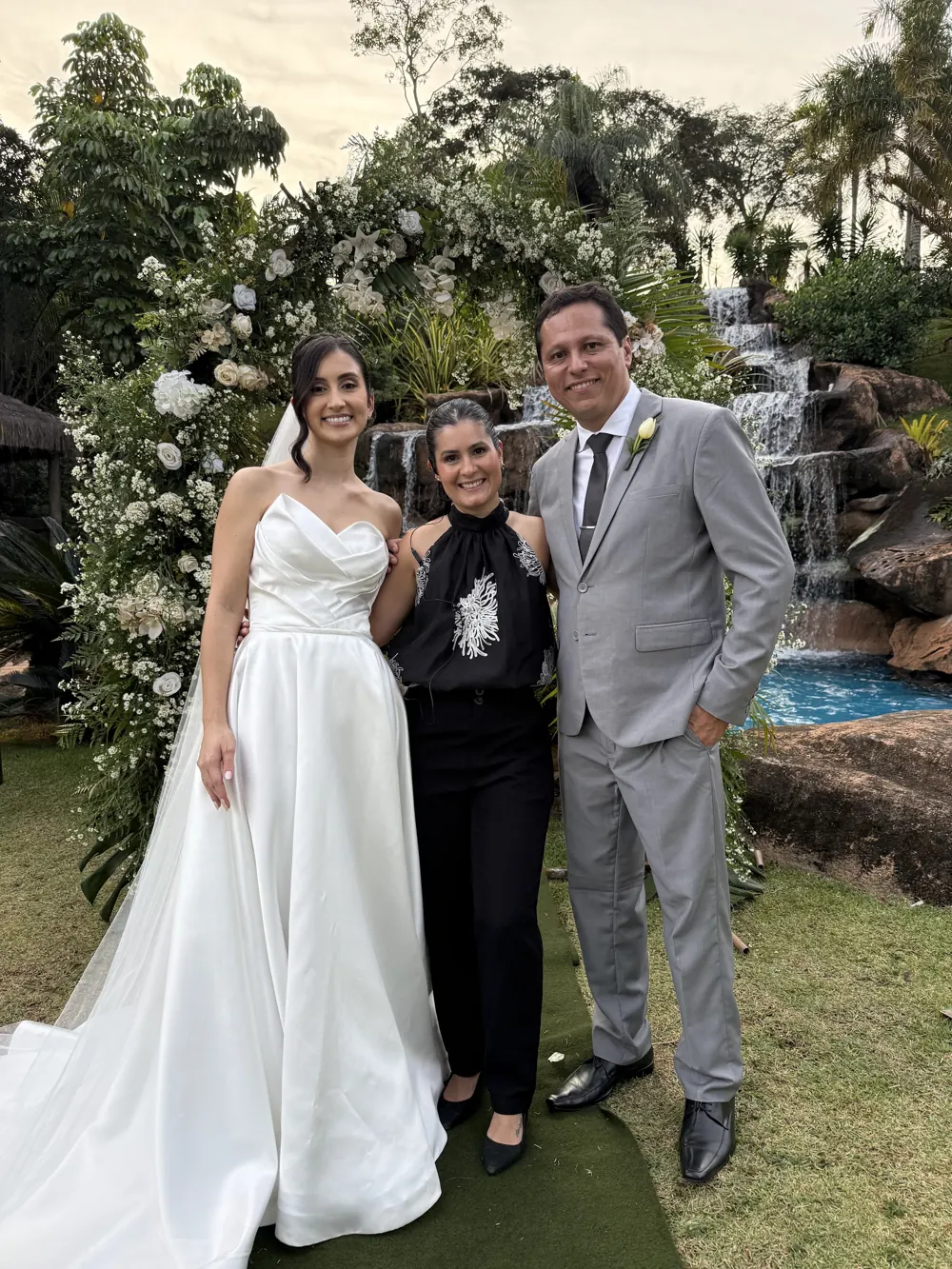Bruna Dias com os noivos junto à cascata, após a cerimônia